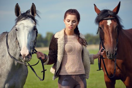 Woman and two horses outdoors