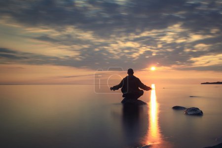 Man meditates on the lake