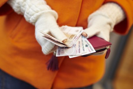 Woman hands holding purse with Russian roubles
