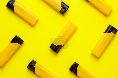 plastic lighters on yellow background