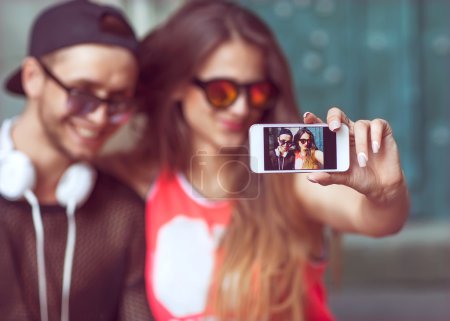 Young fashion couple taking selfie in the city