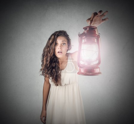 Beautiful girl holding a lantern and looking surprised