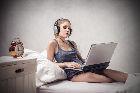 Girl listening to music while using a pc
