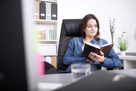 Office Woman Reading a Book While Sitting on Chair
