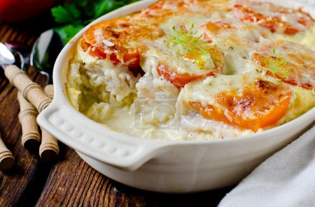 Casserole with rice, sea bass, tomato and cheese