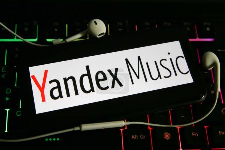 Viersen, Germany - June 1. 2021: Closeup of mobile phone screen with logo lettering of yandex music on computer keyboard