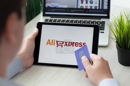 Man holding iPad Pro Internet shopping service Aliexpress on scr