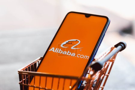 September 2, 2021, Brazil. In this photo illustration the Alibaba.com logo displayed on a smartphone along with a shopping cart