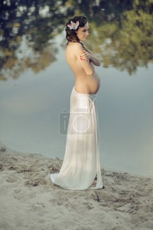 Pregnant nymph realxing by the lakeside