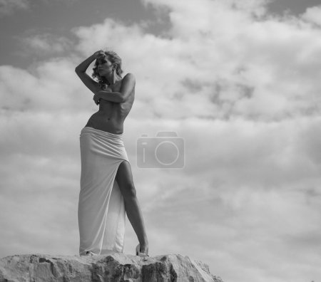 Half-naked woman looking at the rocks