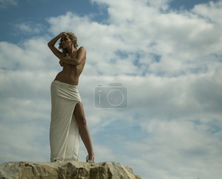 Alluring blond woman over the sky background