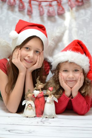 Two glad sisters with santa caps