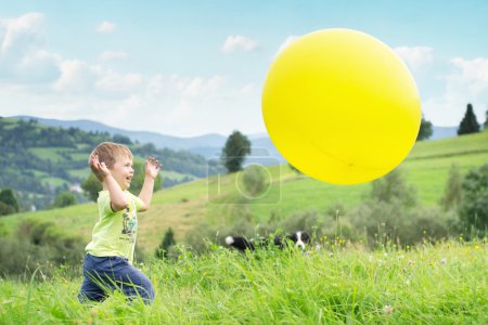 Laughing boy chasing a balloon