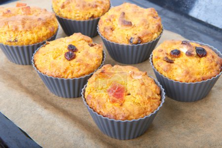 Carrot muffins with apple and candied fruit on a baking
