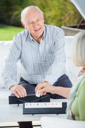 Happy Senior Man Playing Rummy With Woman