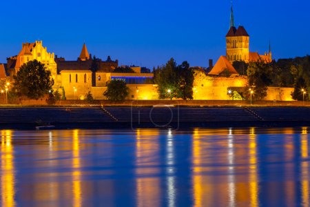 Old town of Torun at night reflected in Vistula river