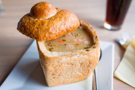 Tasty soup served in baked bread bowl