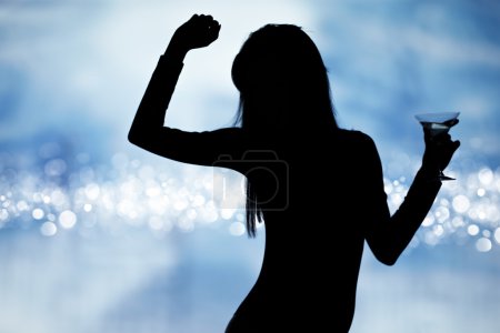 Dancing silhouettes of women with champagne in a nightclub