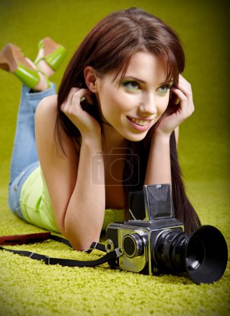 Woman with camera on green spring background