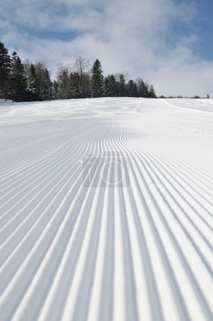 Tracks on ski slopes at beautiful sunny winter day