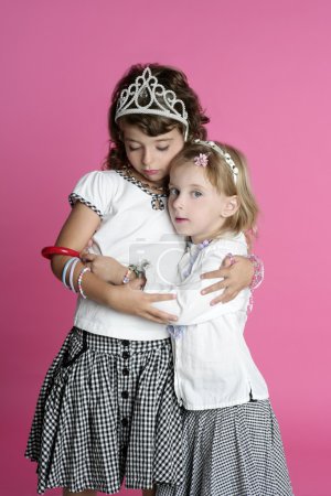 Two sisters little girl friends hug stand