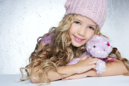 Winter fashion cap little girl hug teddy bear smiling