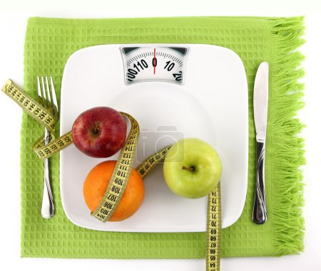 Diet concept. Fruits with measuring tape on a plate like weight scale