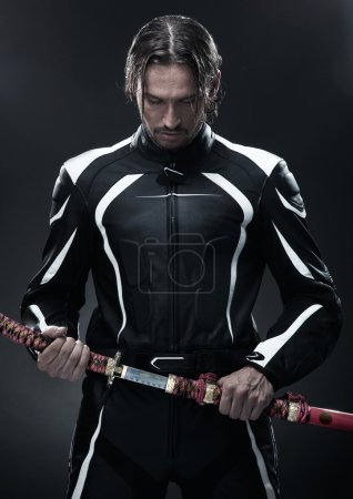 Handsome man holding a samurai sword