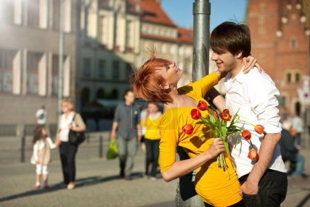 Woman holding flower bouquet smiling at man.