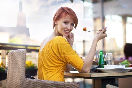 Portrait of young happy smiling woman eating lunch