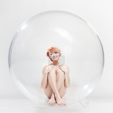 Naked smiling woman in soap ball