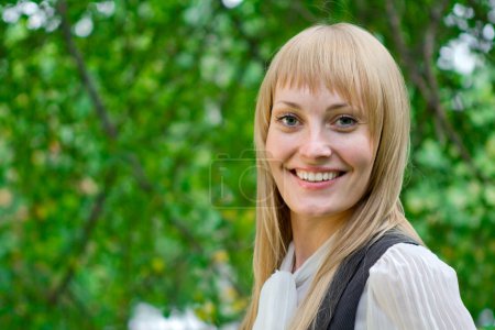 Smiling blonde beautiful woman in the park