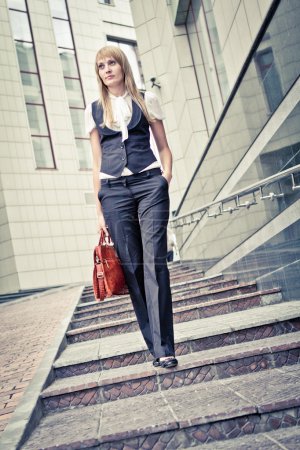 Business woman walks up the stairs