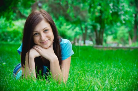 Portrait of a happy young woman lying on grass