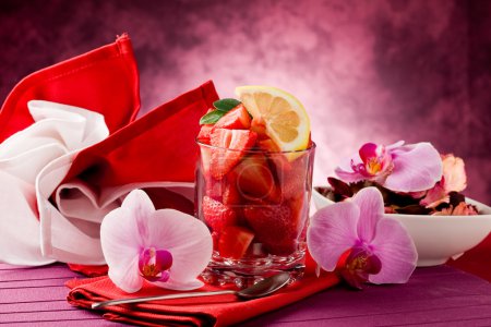 Strawberries with Orchid on red table