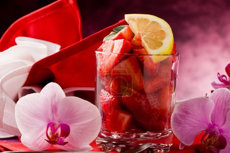 Strawberries with Orchid on red table