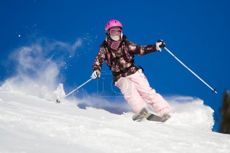 Woman skiing fast. Vibrant sky