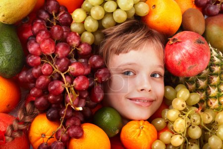 Child girl in group of fruit.