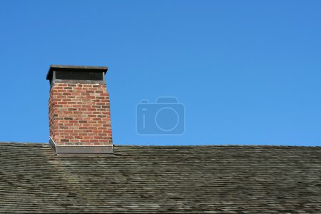 Old roof and chimney with blue sky