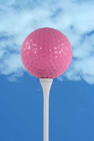 Pink golf ball against blue sky