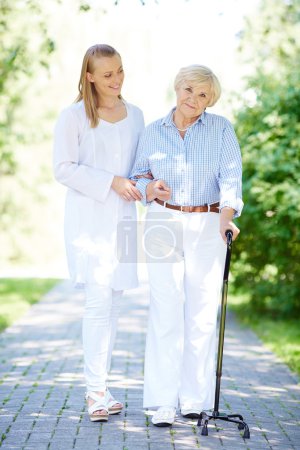 Nurse and senior patient  in park