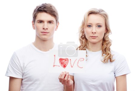 Young couple holding paper with word love