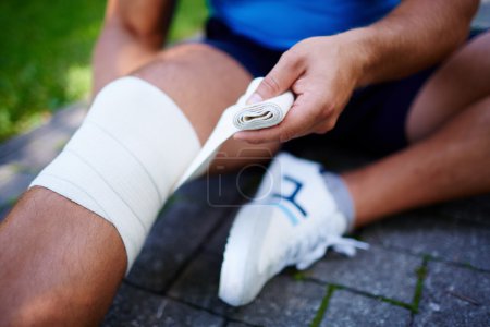 Man bandaging leg