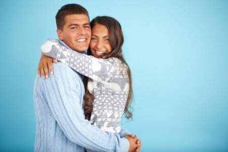 Couple in fashionable pullovers embracing