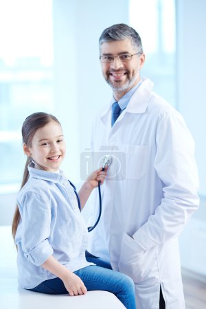 Girl examining doctor with stethoscope