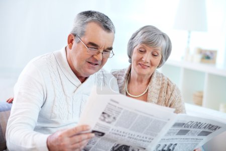 Mature couple reading news