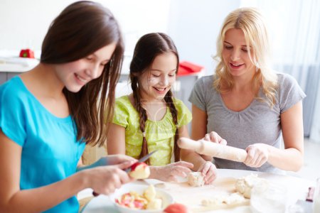 Girls and mother cooking pastry