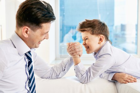 Boy and his dad armwrestling