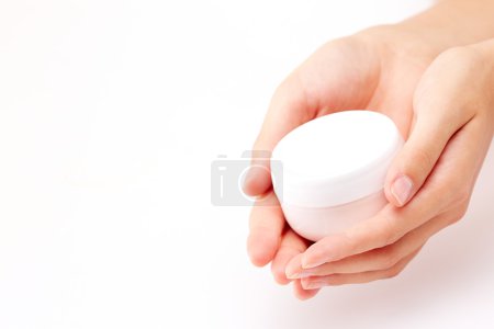 Female manicured hands holding cream