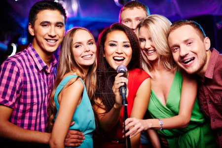 Girls and guys singing  in karaoke bar